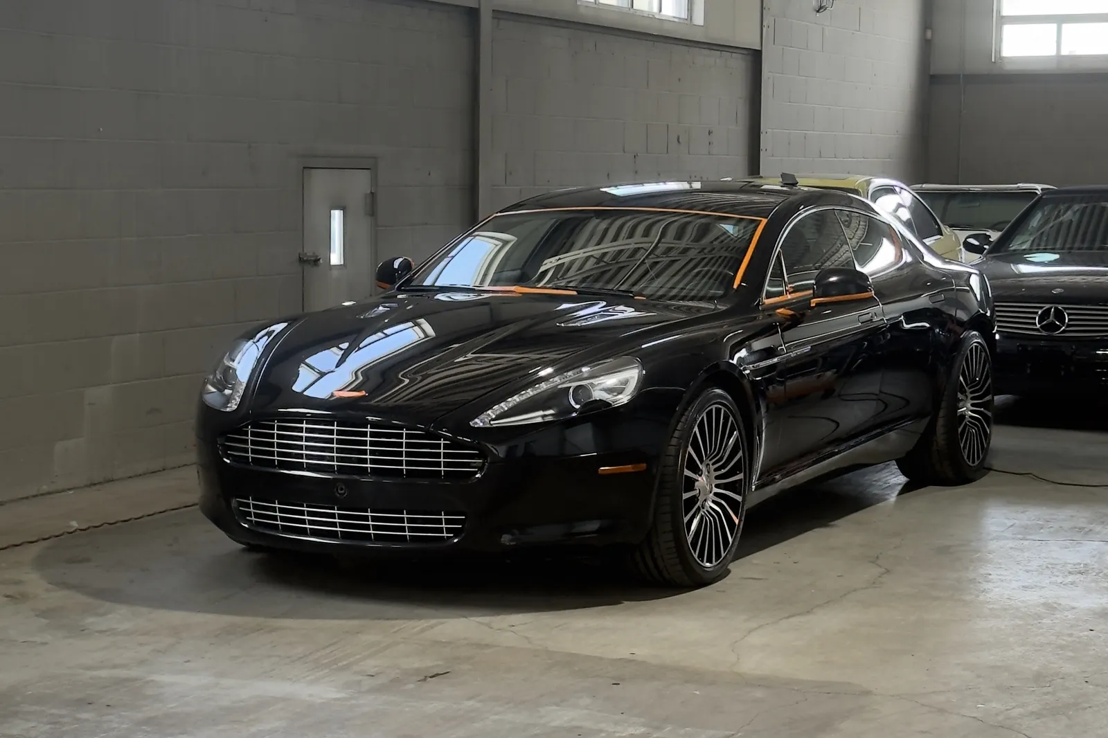 Gloss-black Aston Martin Rapide with a deep, mirror finish